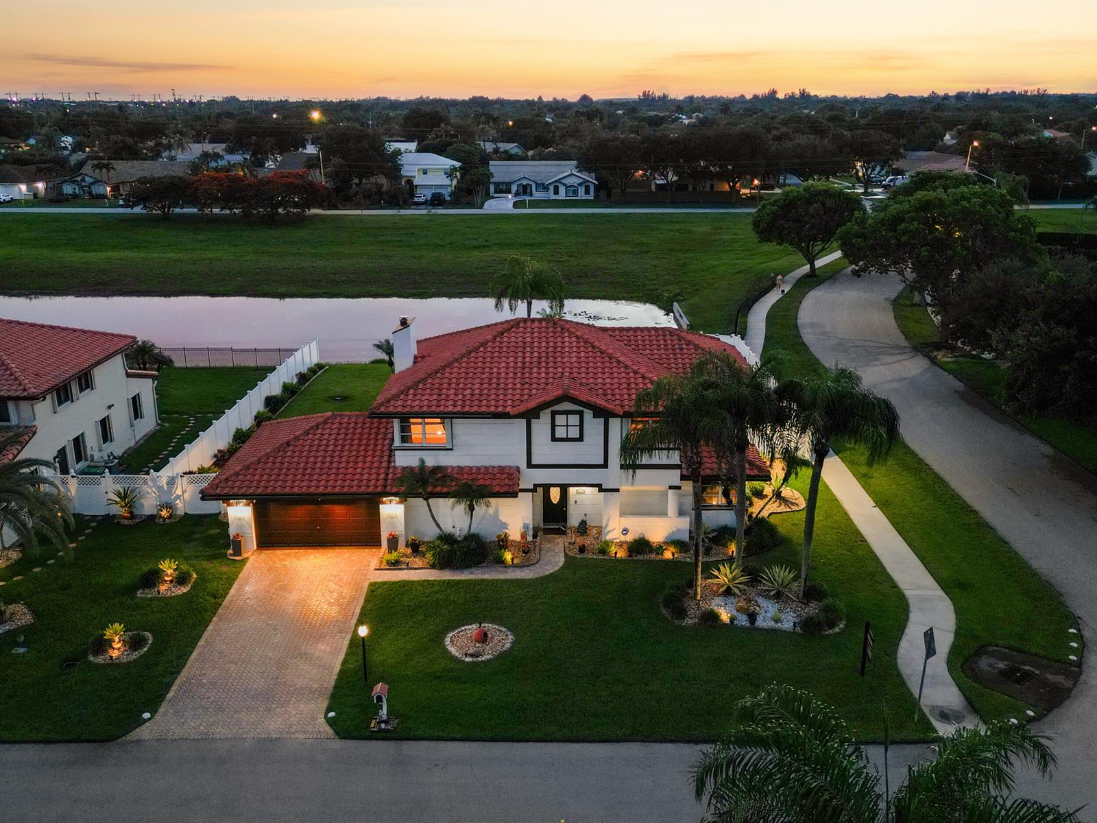 An aerial view shows a two-story house with a red tile roof and paved driveway — 6431 Olde Moat Way, Davie FL 33331, DAVIE, FL