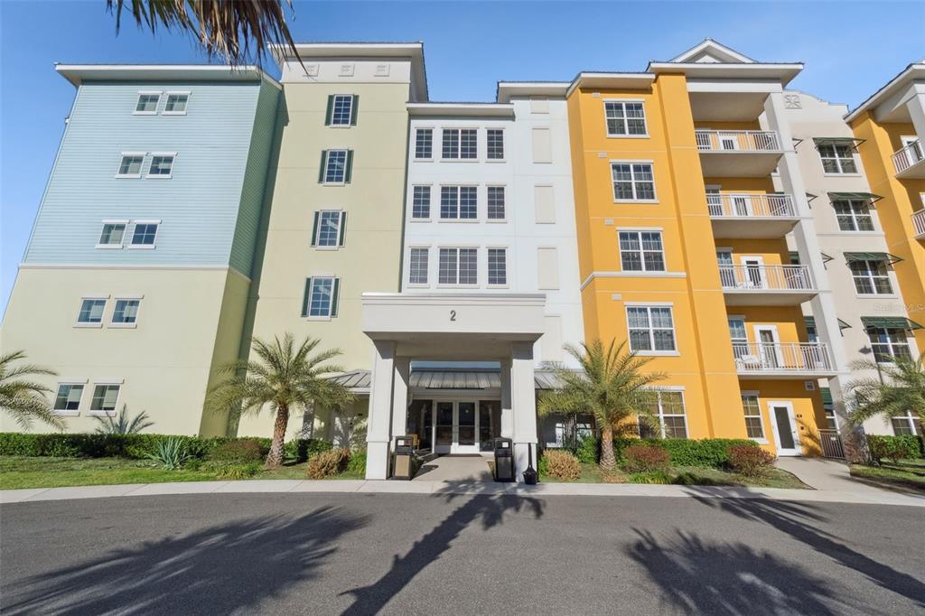 A multi-story apartment building with a central entrance and colorful exterior facades — 8061 VACATION AVENUE UNIT 2510, KISSIMMEE, FL