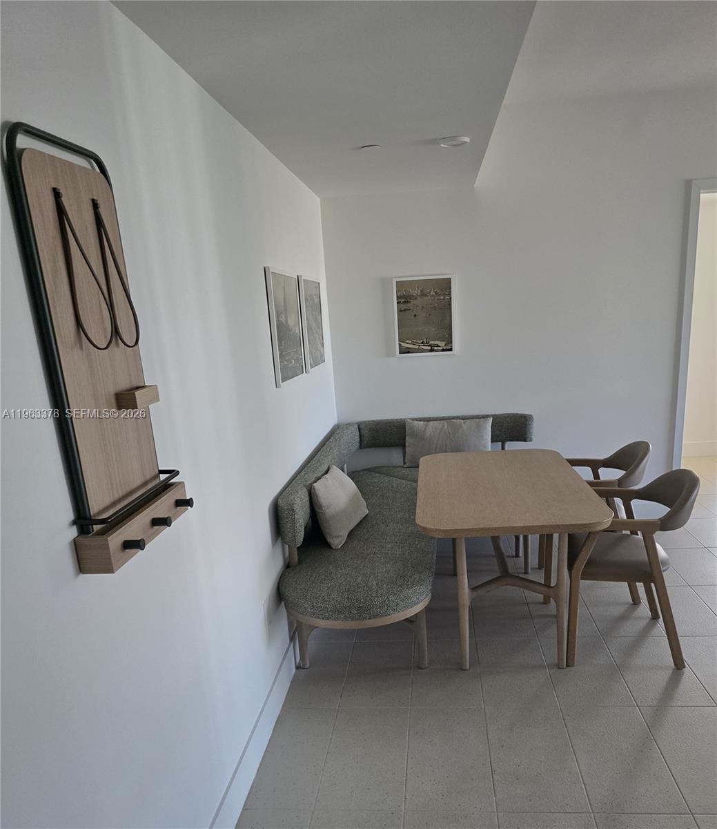 A dining area features a corner banquette, a wooden table, and two chairs — 159 NE 6th St # 4302, Miami FL 33132, MIAMI, FL