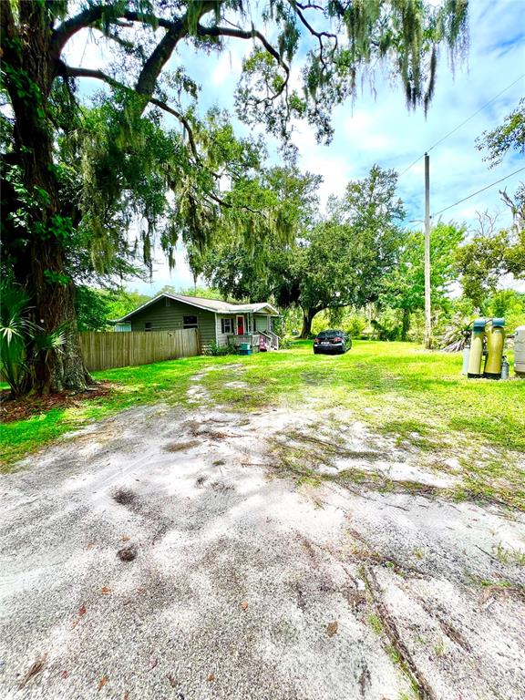 A small house sits at the end of a sandy driveway under large oak trees — 1008 GRAY STREET, PLANT CITY, FL