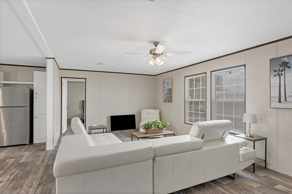 A living room features a white sectional sofa, a ceiling fan, and light-colored walls — 7337 DESANT LANE, PORT CHARLOTTE, FL