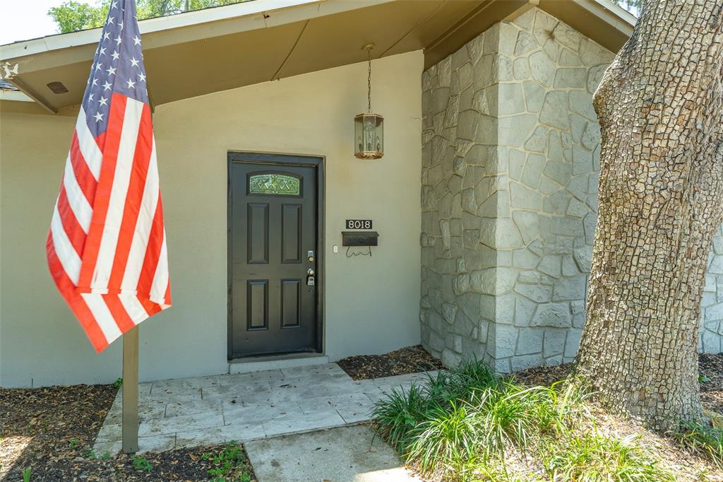 An open-concept kitchen and living area feature wood-look flooring, white cabinetry, and a ceiling fan — 8018 W POCAHONTAS AVENUE, TAMPA, FL