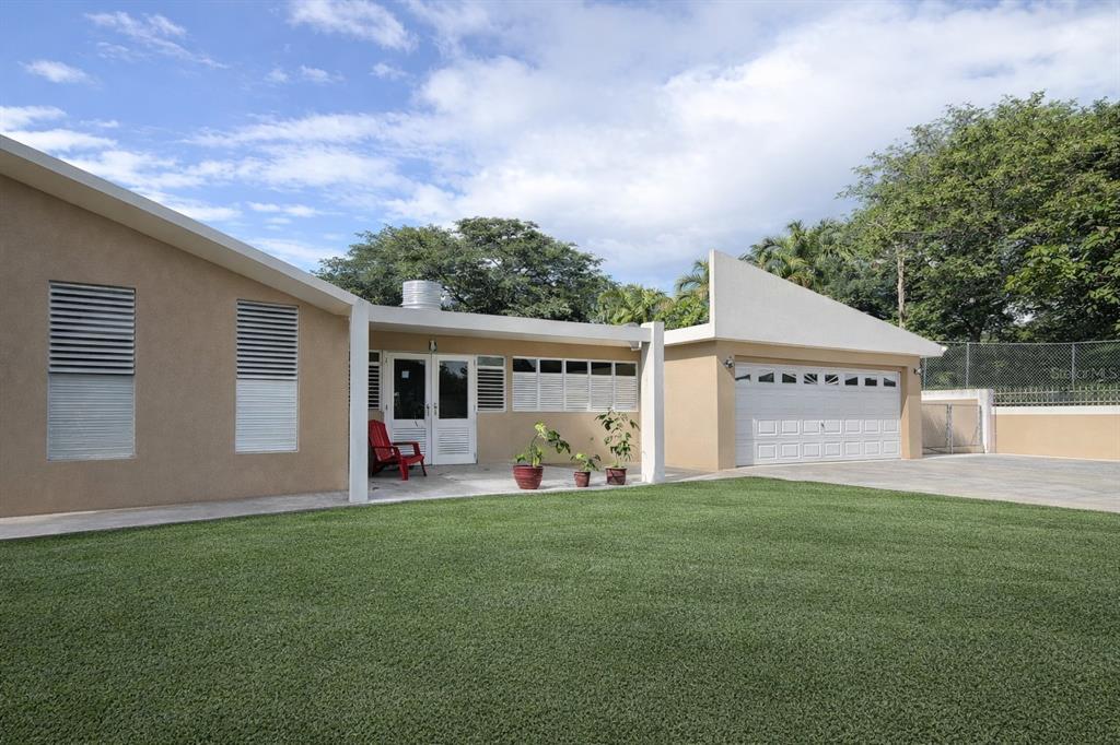 A tan house with a white garage, a covered patio, and a green lawn — Carr 793 KM 1.2 QUINTAS DE JAGUEYES 31A, AGUAS BUENAS, PR