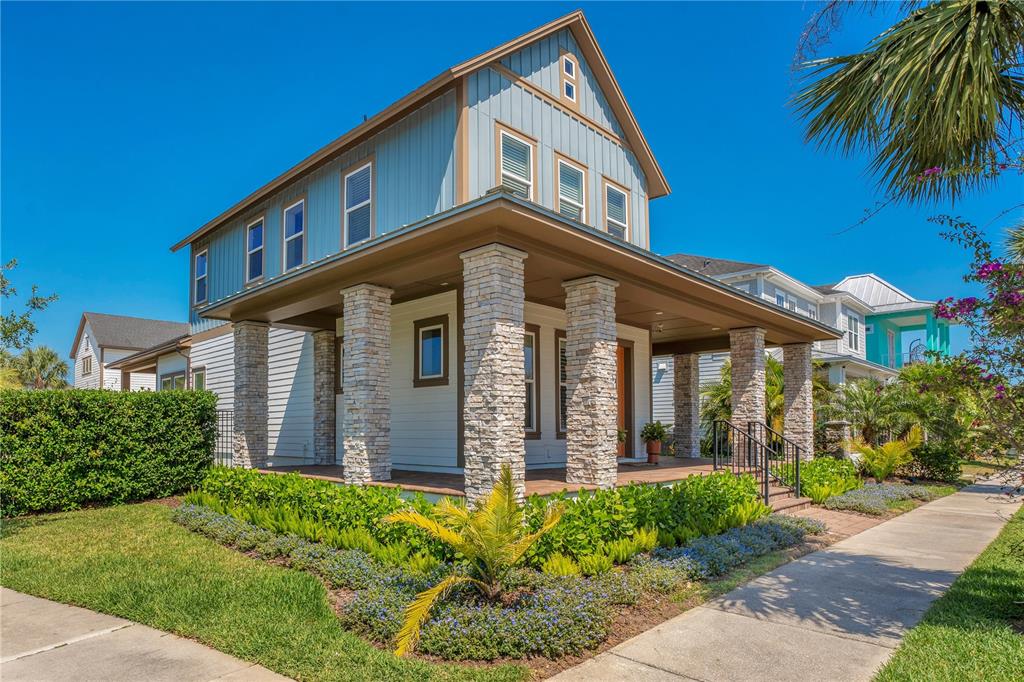 A two-story house with blue siding, a stone-columned porch, and a landscaped front yard — 13101 GABOR AVENUE, ORLANDO, FL