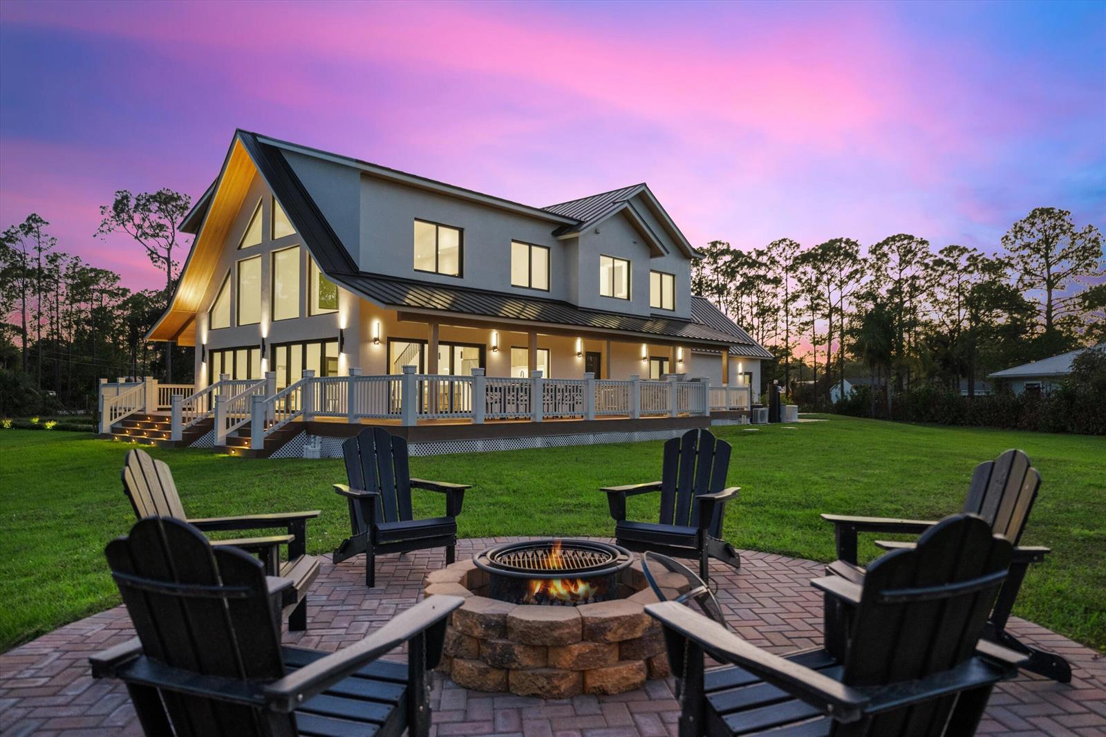 A house with a large deck and a fire pit with chairs on the lawn — 13613 157th Court N, Jupiter FL 33478, JUPITER, FL
