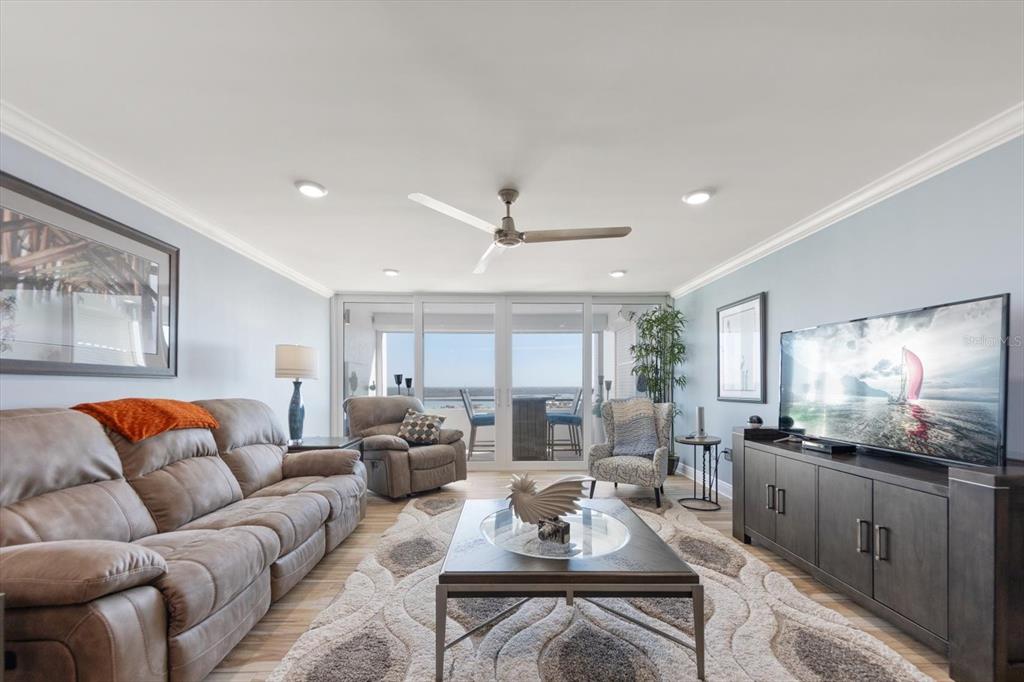 A living room features a brown sofa, a coffee table, a television, and a balcony view — 17920 GULF BOULEVARD UNIT 1901, REDINGTON SHORES, FL