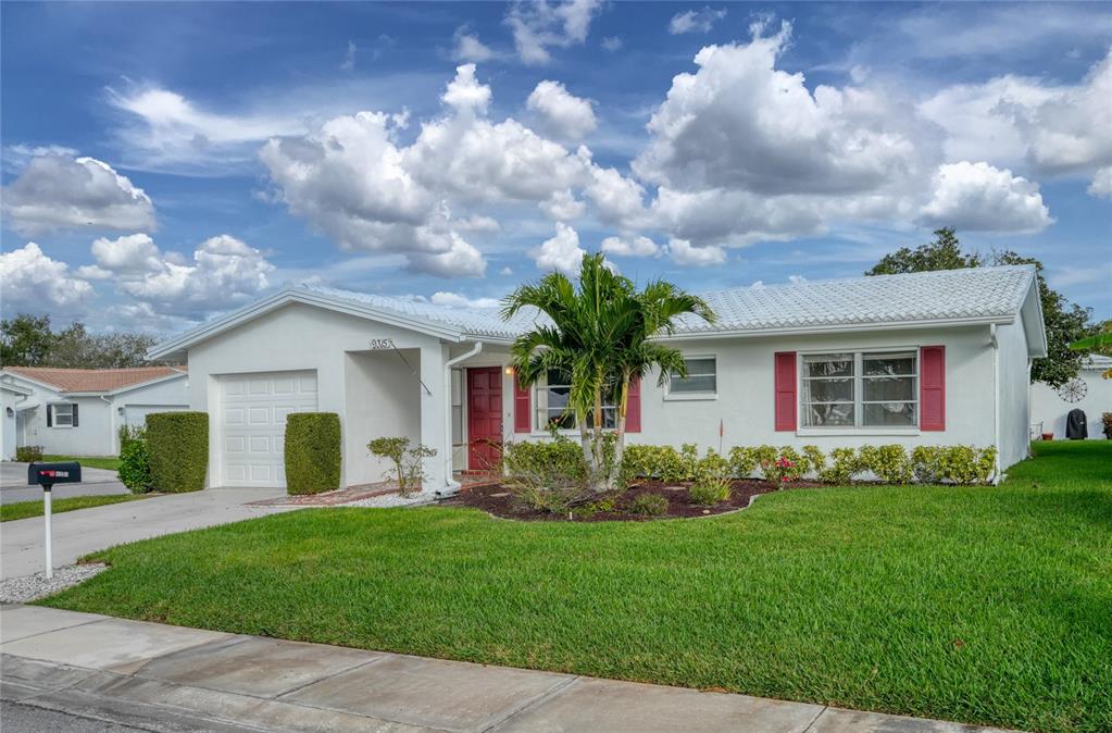 A single-story white house with a red door, red shutters, and a palm tree — 9315 42ND WAY N UNIT #5, PINELLAS PARK, FL