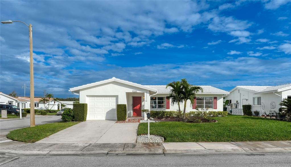 A white single-story house with a garage, red front door, and a green lawn — 9315 42ND WAY N UNIT #5, PINELLAS PARK, FL