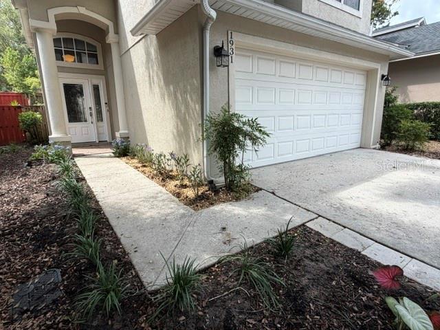 A two-story house with a beige exterior, a two-car garage, and a front driveway — 1931 LOST SPRING COURT, LONGWOOD, FL