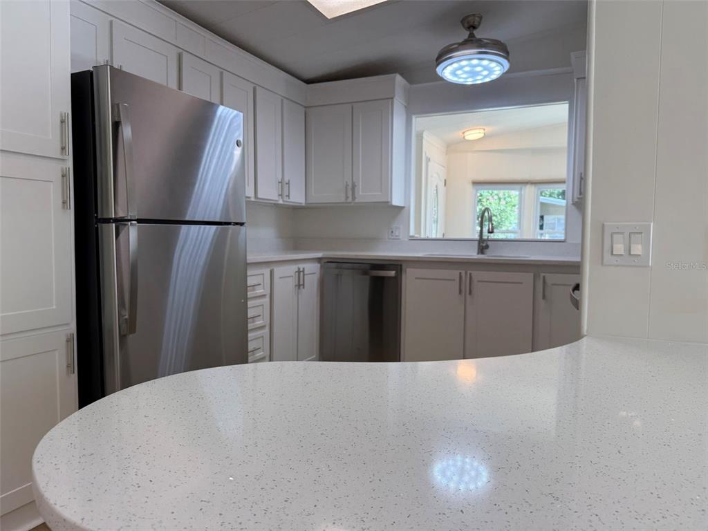 A kitchen with white cabinets, stainless steel appliances, and a white speckled countertop — 130 CLUBVIEW DRIVE UNIT 2, SAFETY HARBOR, FL