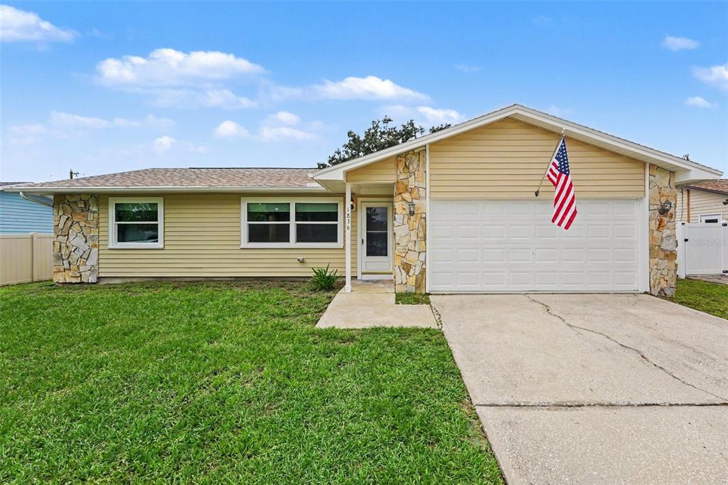 A single-story house with yellow siding, stone accents, and a front-facing garage — 1836 DIANE DRIVE, CLEARWATER, FL