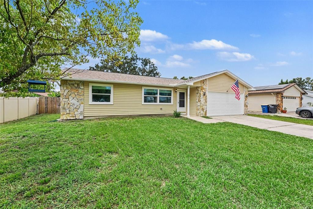A single-story house with yellow siding, stone accents, and a front-facing garage — 1836 DIANE DRIVE, CLEARWATER, FL