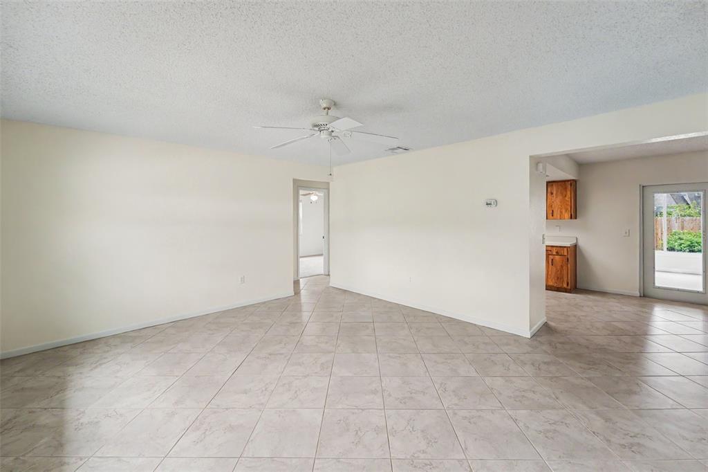 A living room with light-colored tile flooring, white walls, and a ceiling fan — 1836 DIANE DRIVE, CLEARWATER, FL