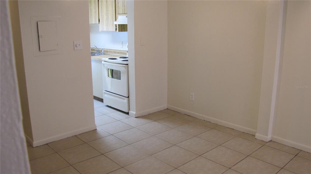 A tiled dining area opens into a kitchen featuring a white stove and light cabinets — 5122 TEMPLE HEIGHTS ROAD UNIT C, TAMPA, FL