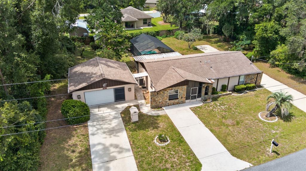 An aerial view shows a single-story house with a detached garage and a screened pool — 5080 E PRENTICE LANE, INVERNESS, FL