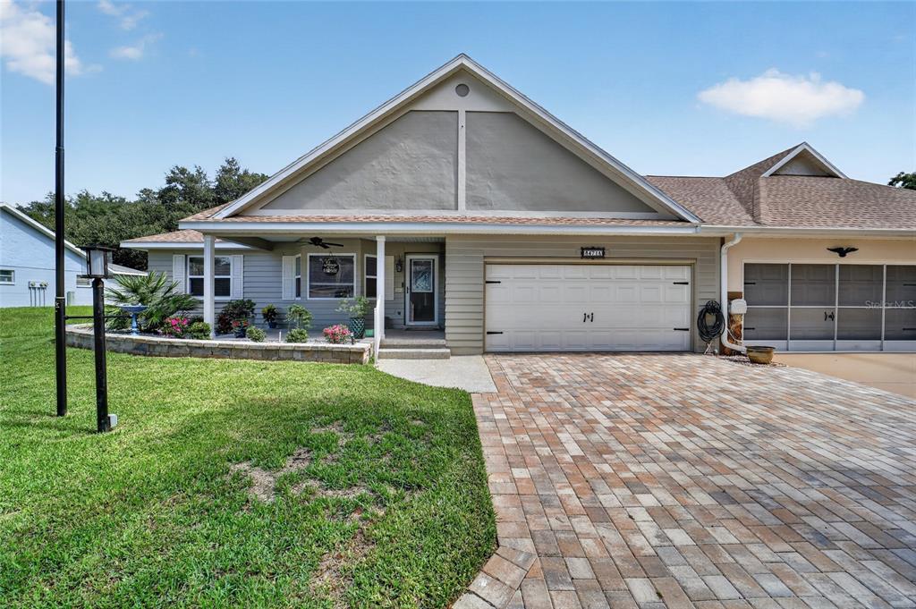 A single-story house with a beige facade, a paved driveway, and a front porch — 8471 SW 91ST STREET UNIT A, OCALA, FL