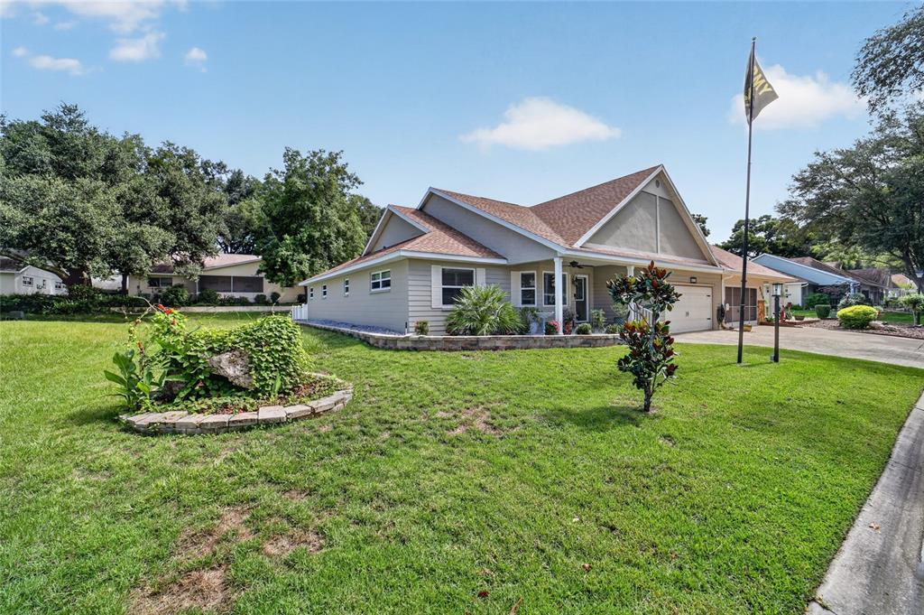 A tan, single-story house with a gabled roof and a flag pole in the front yard — 8471 SW 91ST STREET UNIT A, OCALA, FL