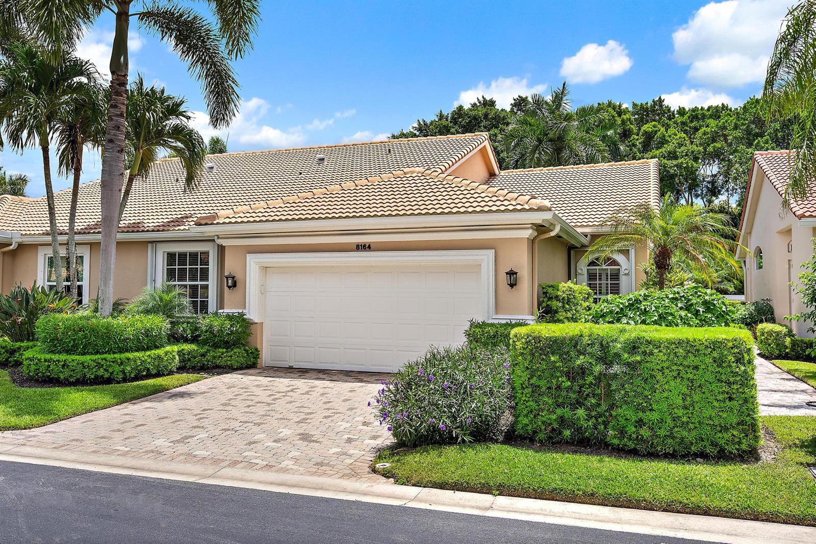 A single-story house with a beige stucco exterior, a tiled roof, and a paved driveway — 8164 Sandpiper Way, West Palm Beach FL 33412, WEST PALM BEACH, FL