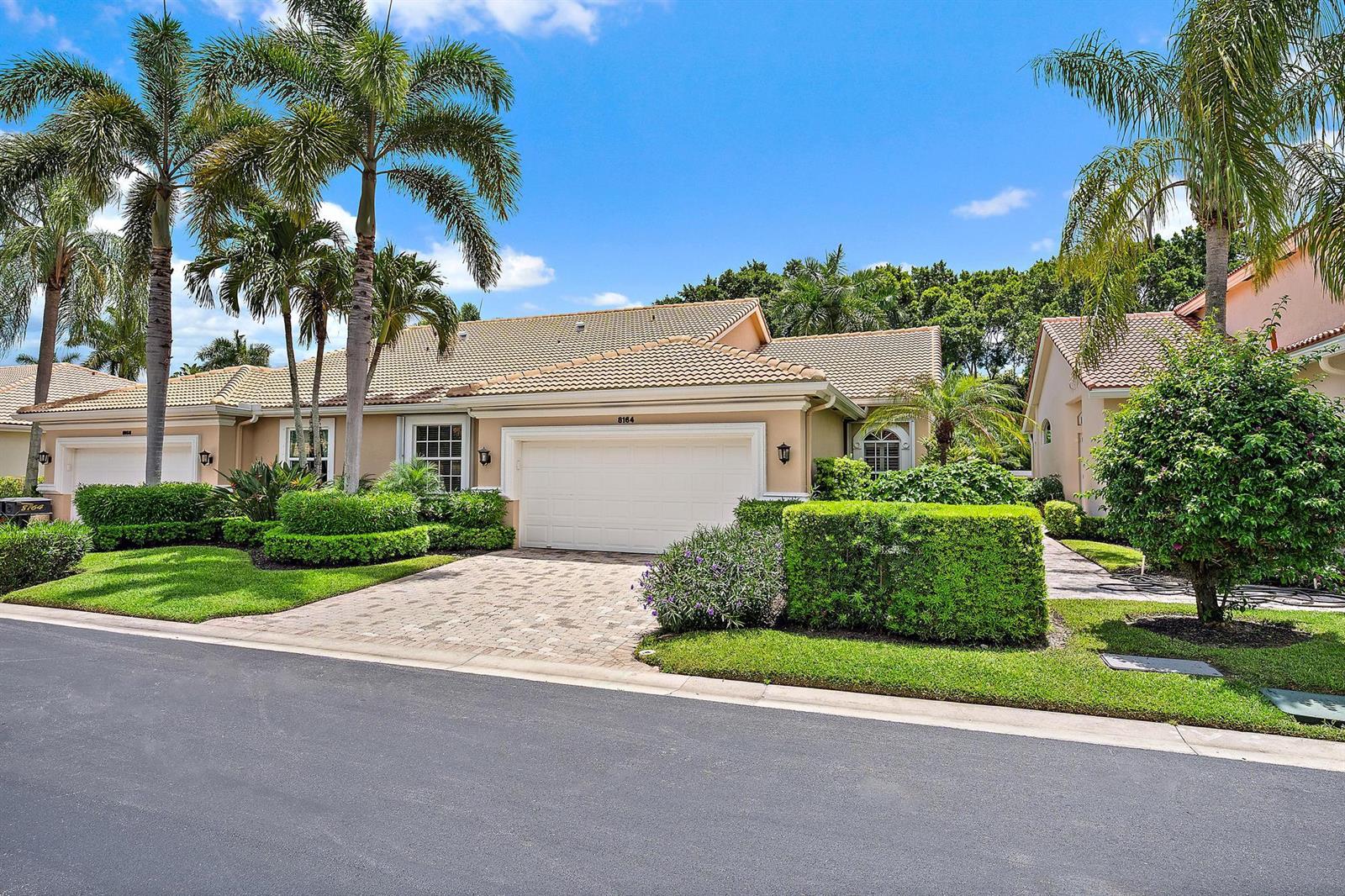 A single-story house with a beige exterior, a two-car garage, and palm trees in front — 8164 Sandpiper Way, West Palm Beach FL 33412, WEST PALM BEACH, FL