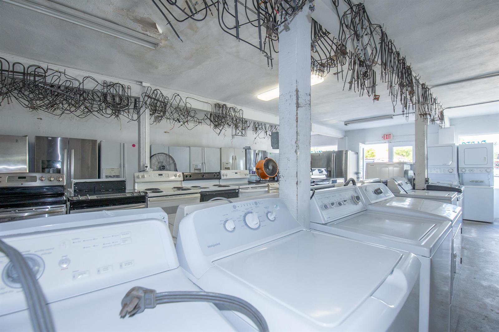 A warehouse space filled with various used household appliances like washing machines, dryers, and refrigerators — 928 S Dixie Highway, FL 33460, FL