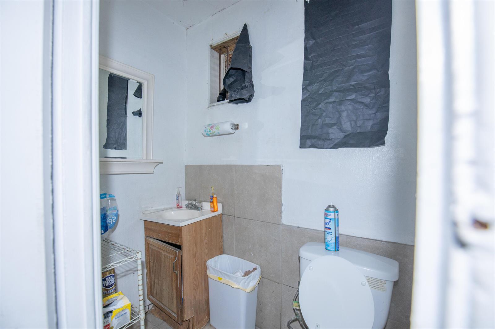 A small bathroom features a vanity, a toilet, a mirror, and a window with a covering — 928 S Dixie Highway, FL 33460, FL