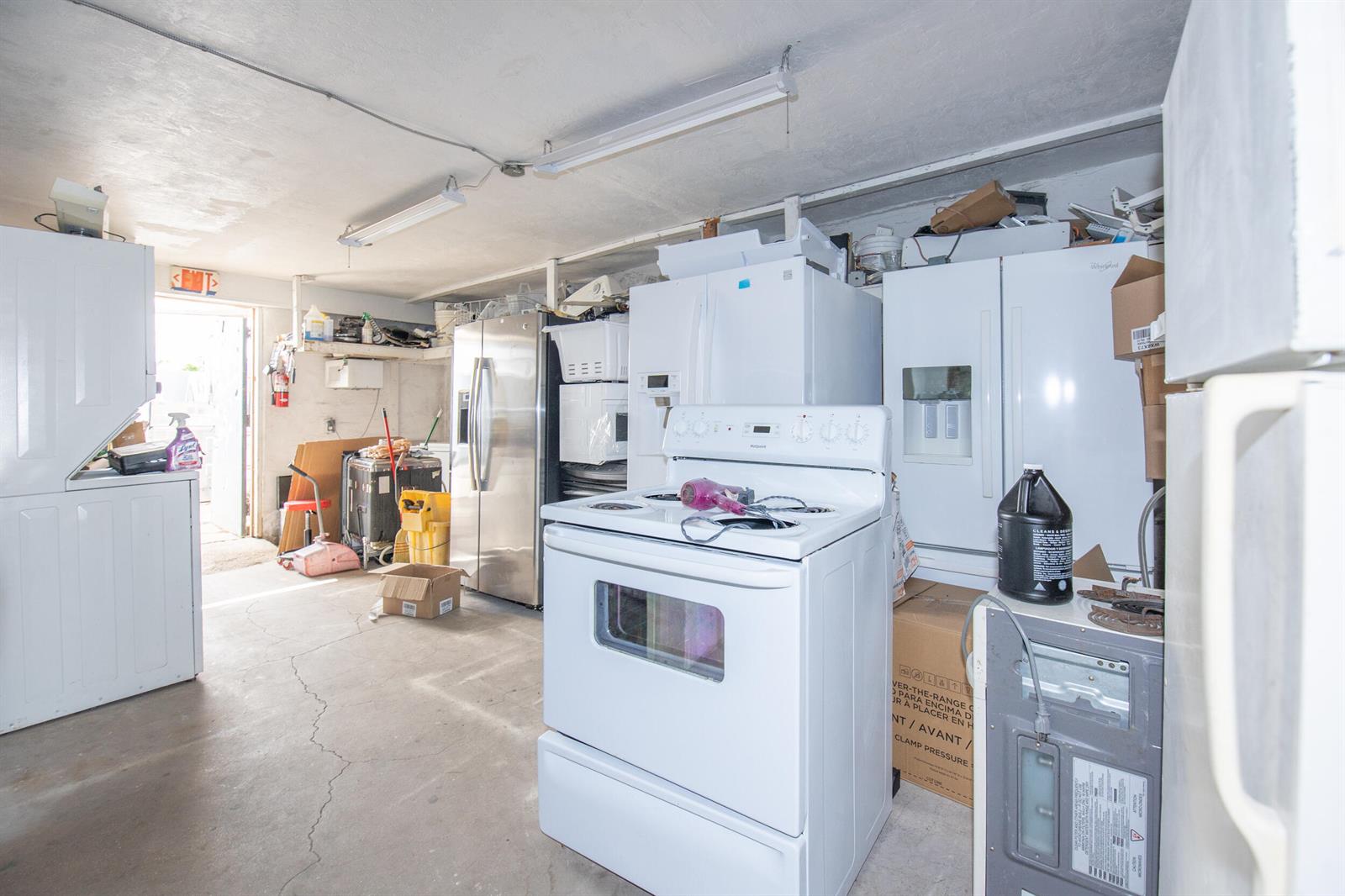 A cluttered storage room or garage contains several white and stainless steel kitchen appliances — 928 S Dixie Highway, FL 33460, FL