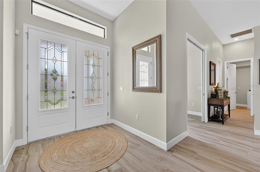 An entryway features a double front door with glass inserts, tile flooring, and a mirror — 592 ROTONDA CIRCLE, ROTONDA WEST, FL