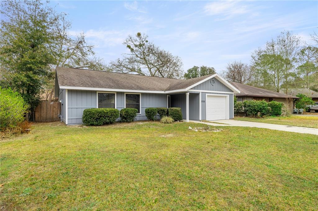 A single-story gray house with a white garage door and a front lawn — 3730 NW 61ST PLACE, GAINESVILLE, FL