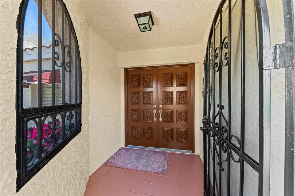 A front entryway features a double brown door, a purple rug, and black security gates — 6101 34TH STREET W UNIT 3D, BRADENTON, FL