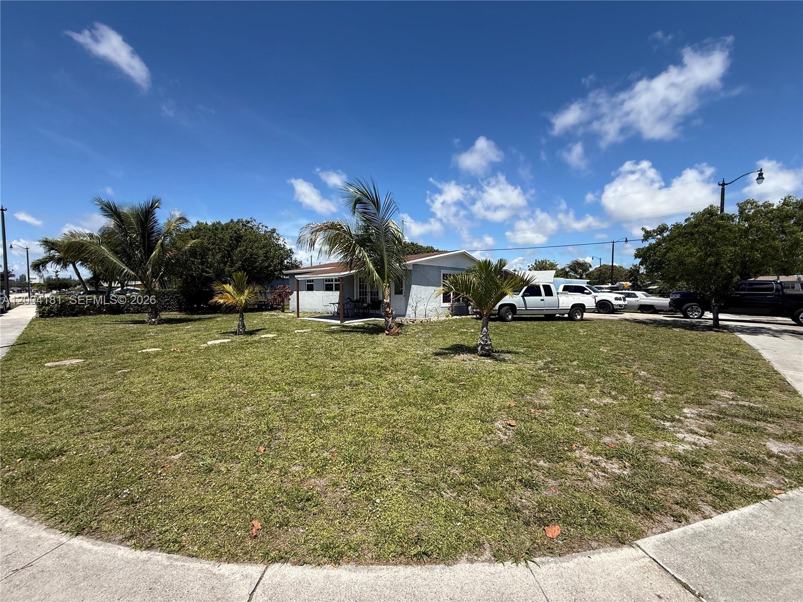 A single-story house with a lawn and palm trees under a blue sky — 1701 NW 6th Ave, Pompano Beach FL 33060, POMPANO BEACH, FL
