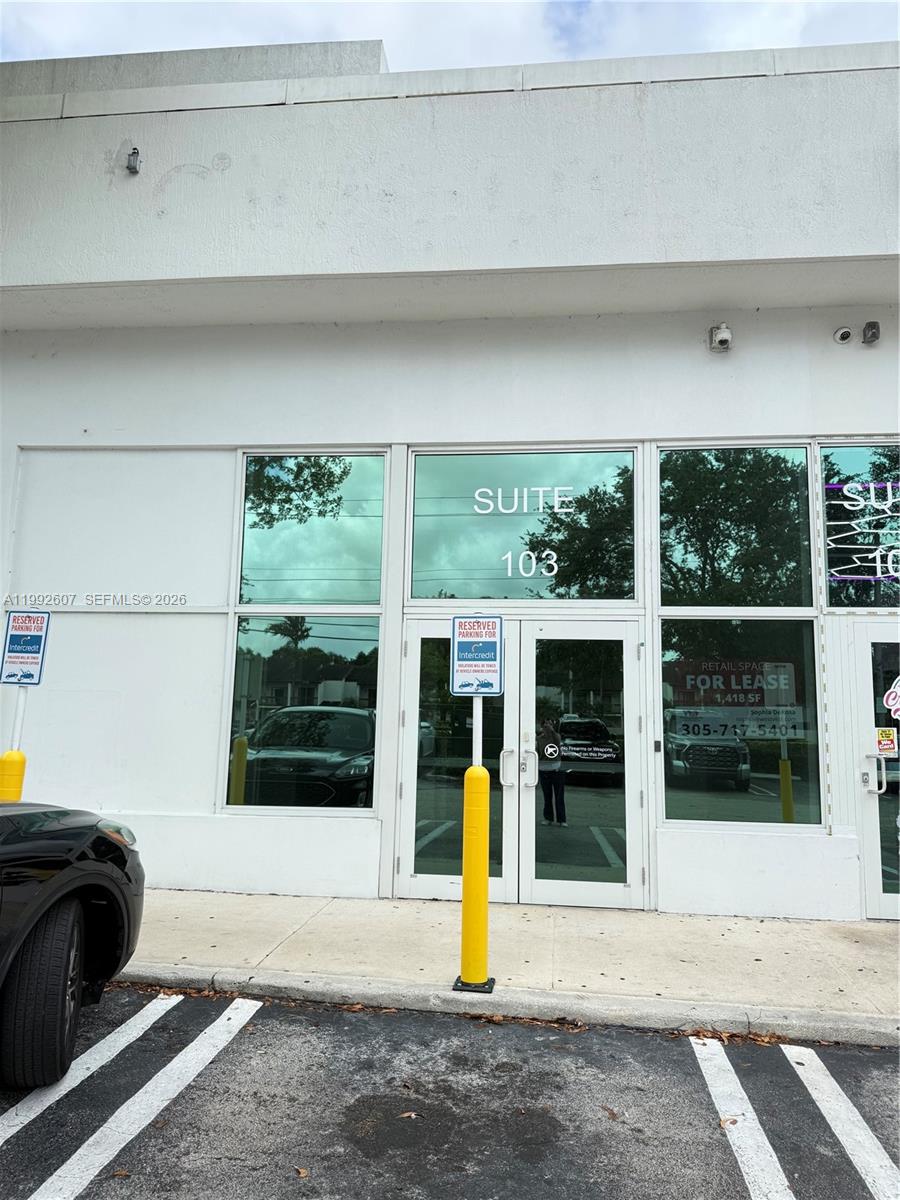 The exterior of a commercial building features a glass-fronted entrance labeled Suite 103 — 10015 NW 41st St # 103, Doral FL 33178, DORAL, FL
