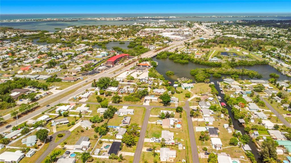 An aerial view shows a residential neighborhood with houses, a road, and nearby waterways — 1161 KEHOSEE LANE, ENGLEWOOD, FL