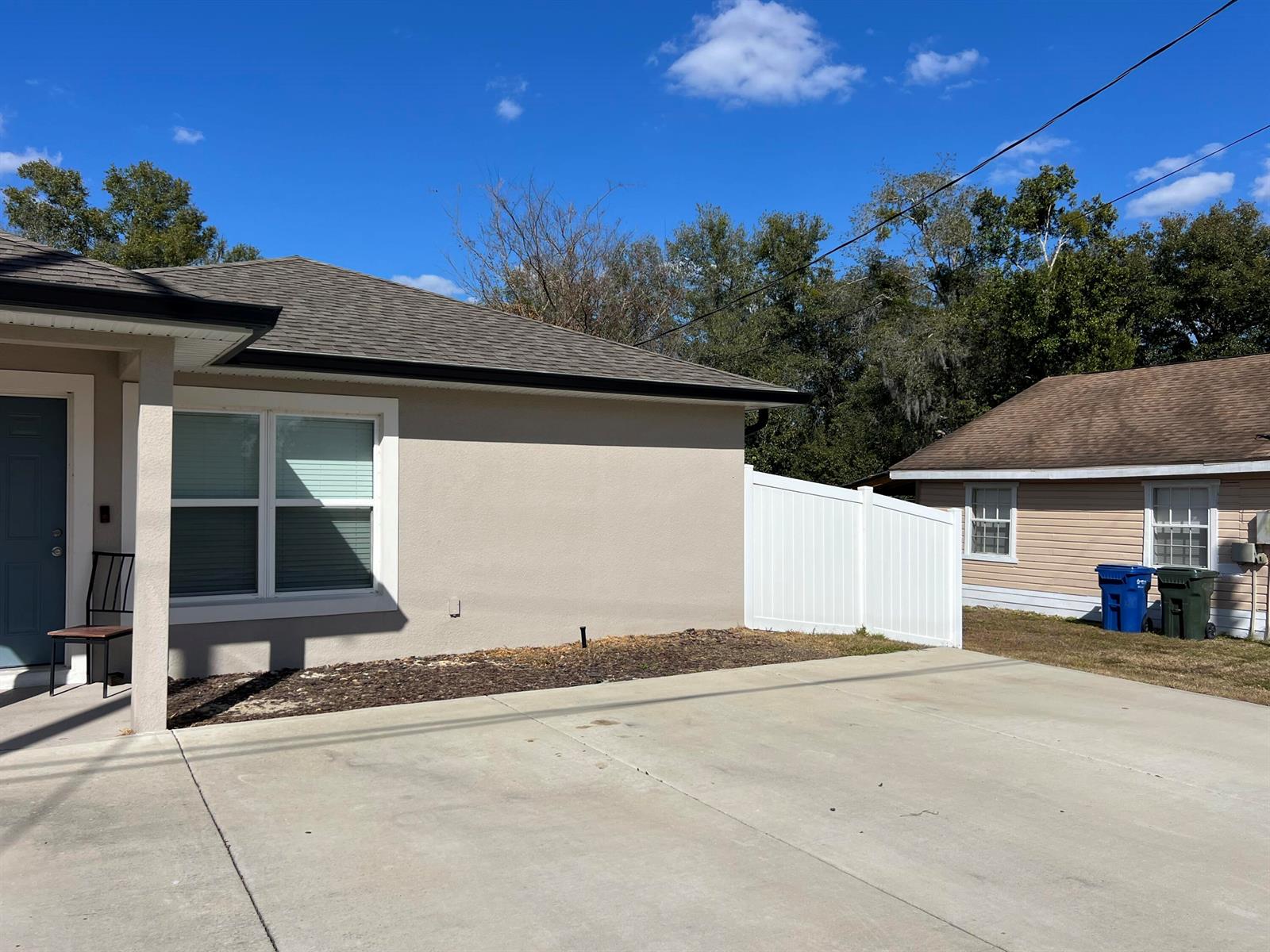 A beige house with a concrete driveway and a white vinyl fence in the yard — 650 E Grapefruit Avenue # A, FL 33850, FL