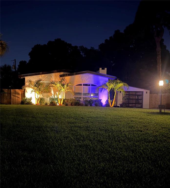 A single-story house at night with illuminated palm trees and a lit garage door — 6228 7TH AVENUE N, ST PETERSBURG, FL