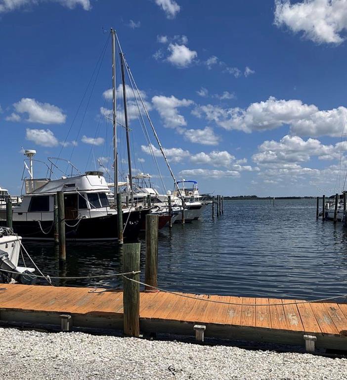 Several boats are docked at a wooden pier under a blue sky with clouds — 3723 116TH STREET W, BRADENTON, FL