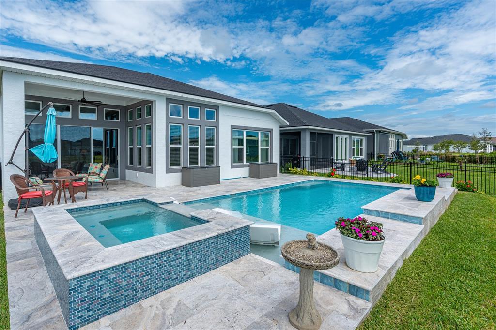 A backyard features a swimming pool, a raised spa, and a patio with outdoor furniture — 268 MOSAIC BOULEVARD, DAYTONA BEACH, FL