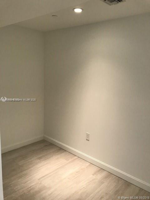 An empty room features light-colored wood-look flooring, white walls, and a recessed ceiling light — 55 SW 9th St # 2510, Miami FL 33130, MIAMI, FL