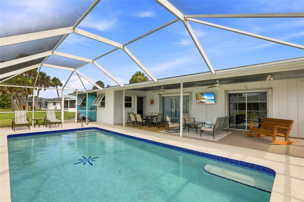 A swimming pool with a screened-in lanai and patio furniture under a covered porch — 1795 ELINOR PLACE, ENGLEWOOD, FL