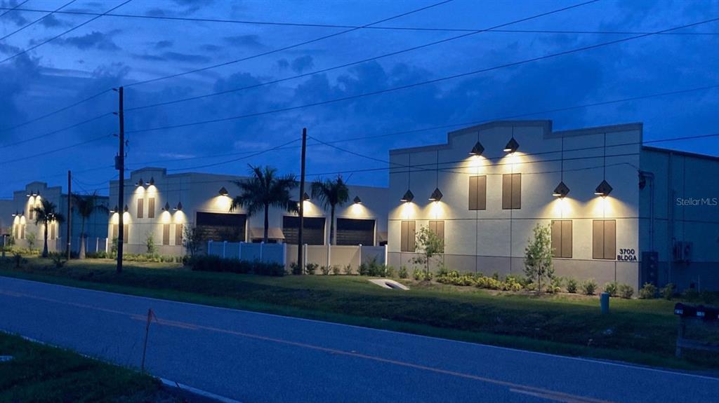 An exterior view of a commercial building complex with exterior lighting at dusk — 5233 TAYLOR ROAD UNIT B1, PUNTA GORDA, FL
