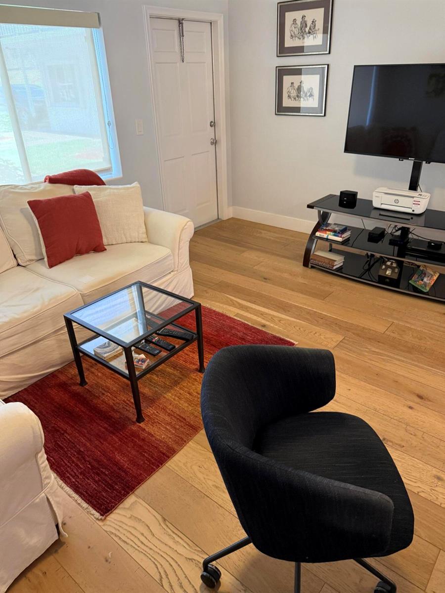 A living room features a white sofa, a black glass coffee table, and a dark chair — 2920 Cynthia Lane # 107, FL 33461, FL