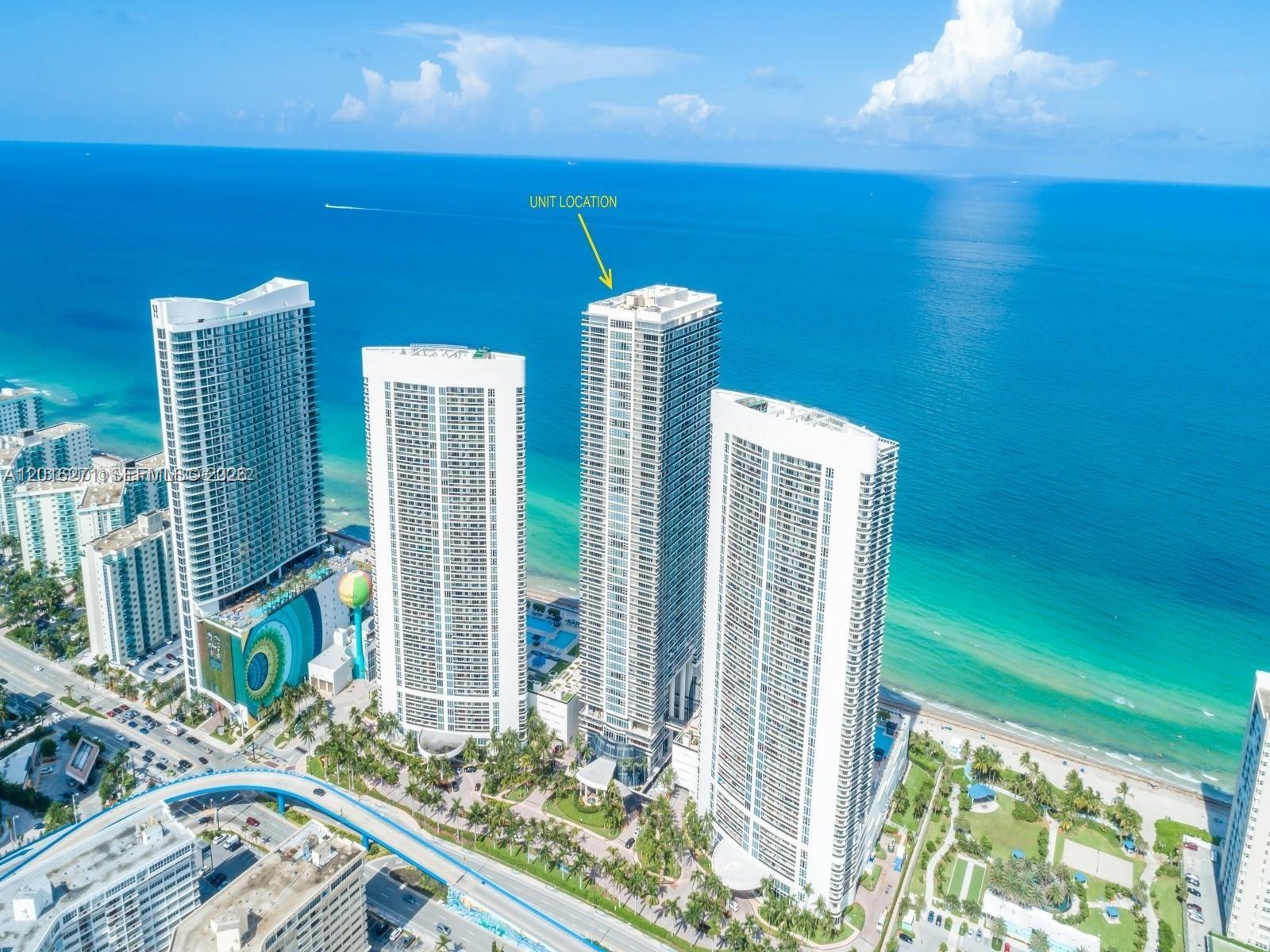 An aerial view shows four tall residential towers situated along a sandy beach and ocean — 1830 S Ocean Dr # 4903, Hallandale Beach FL 33009, HALLANDALE BEACH, FL