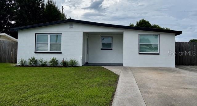 The exterior of a white, single-story concrete block house with a concrete driveway and lawn — 4533 W FERN STREET, TAMPA, FL