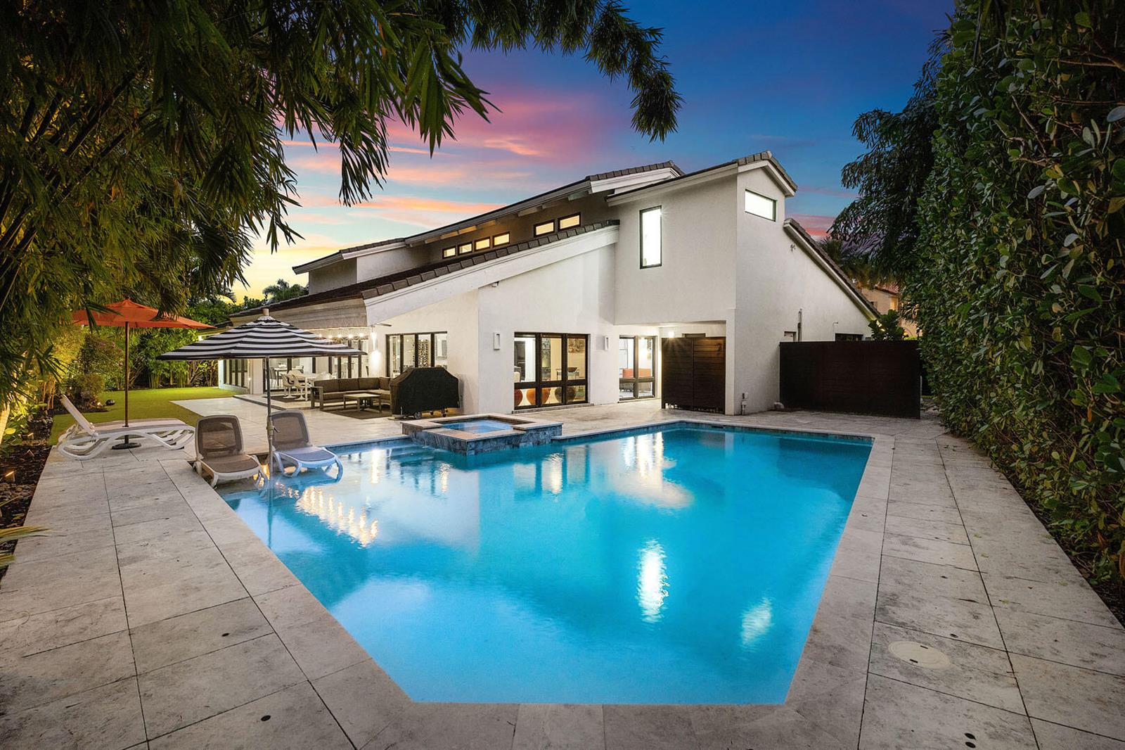 A modern two-story house with a swimming pool, hot tub, and patio at sunset — 229 S Maya Palm Drive, Boca Raton FL 33432, BOCA RATON, FL