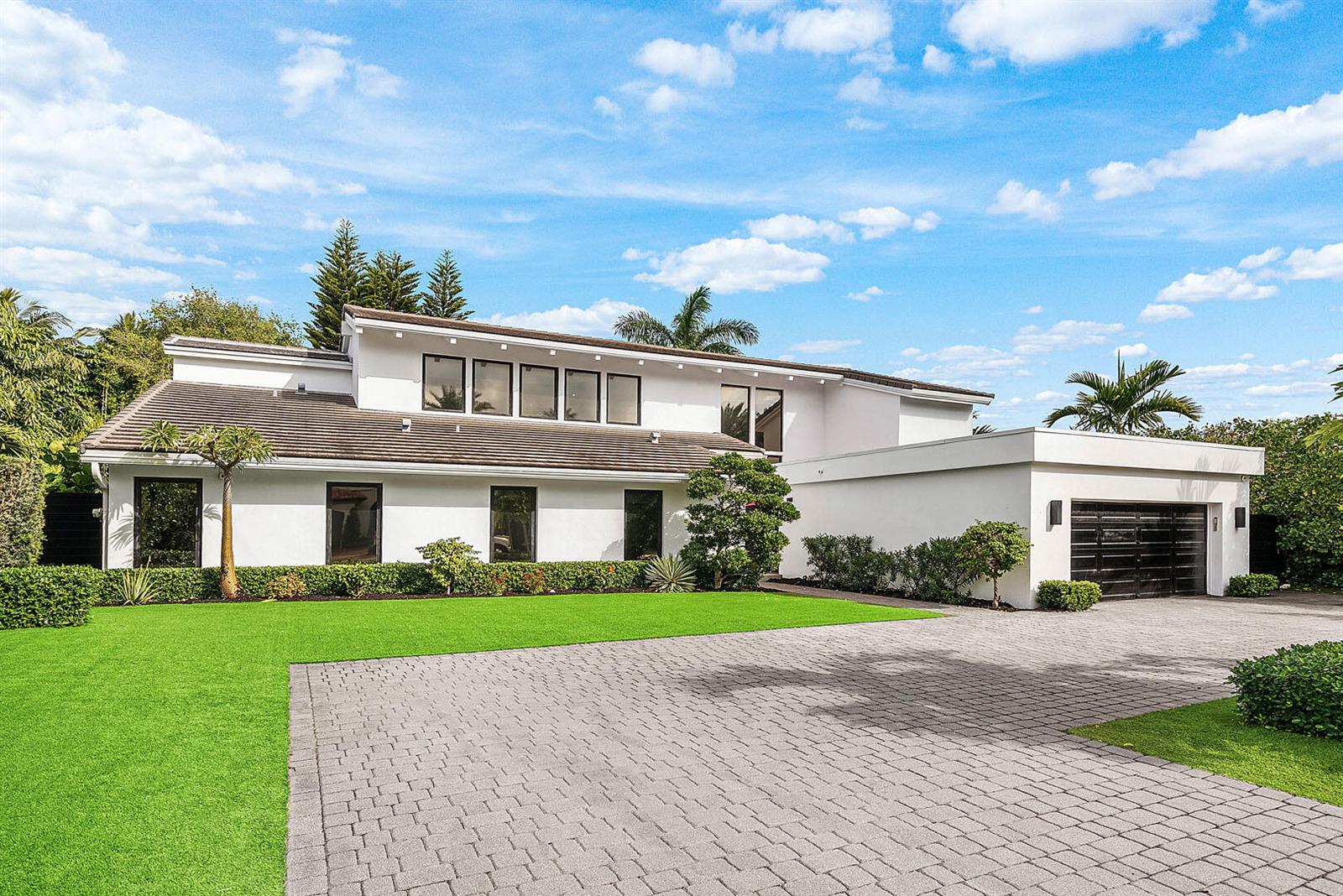 A two-story white house with a paved driveway, green lawn, and a dark garage door — 229 S Maya Palm Drive, Boca Raton FL 33432, BOCA RATON, FL