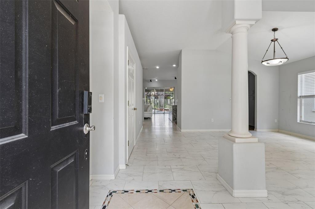 A view from an open front door into a tiled entryway with a decorative column — 4643 DUNNIE DRIVE, TAMPA, FL