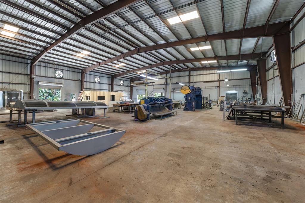 A spacious industrial workshop features a concrete floor, metal framing, and various metalworking machinery — PR-1 BO RIO SECTOR LOS SANTA UNIT 5, GUAYNABO, PR
