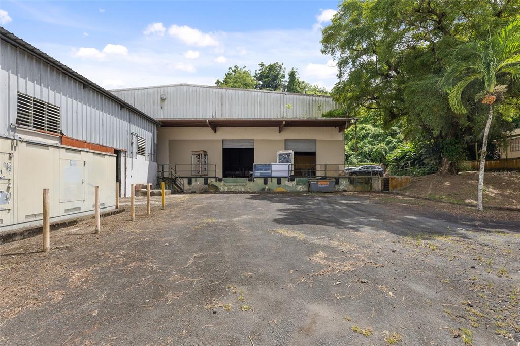 An exterior view of a warehouse building with a loading dock and paved lot — PR-1 BO RIO SECTOR LOS SANTA UNIT 5, GUAYNABO, PR