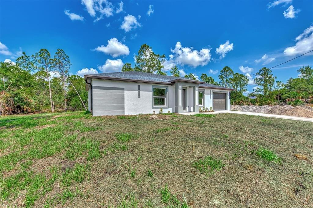 A modern, single-story house with a white exterior, gray trim, and a two-car garage — 5465 TYSON STREET, NORTH PORT, FL