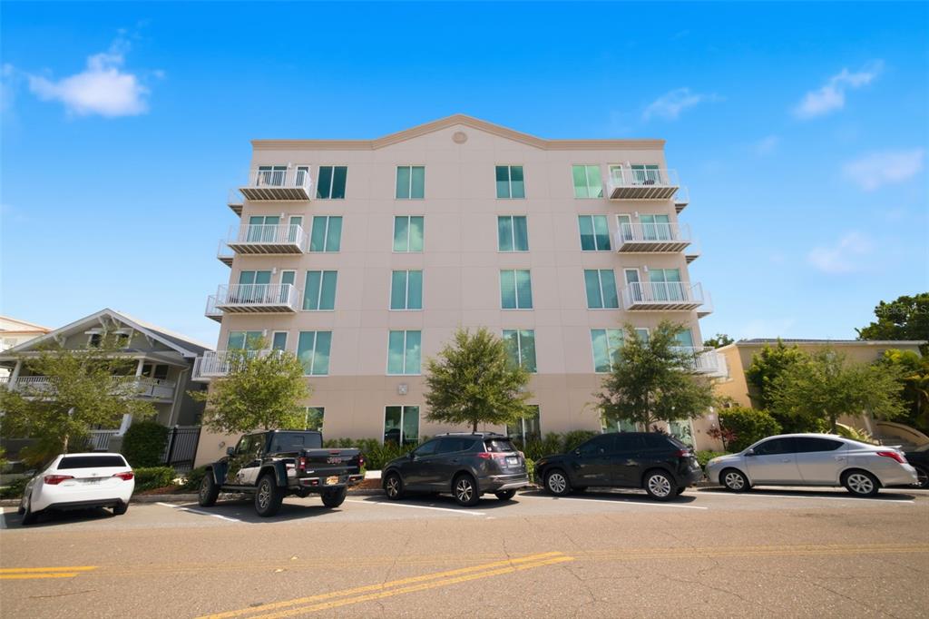 A multi-story apartment building with balconies and a parking lot in front — 644 3RD AVENUE S UNIT 403, ST PETERSBURG, FL