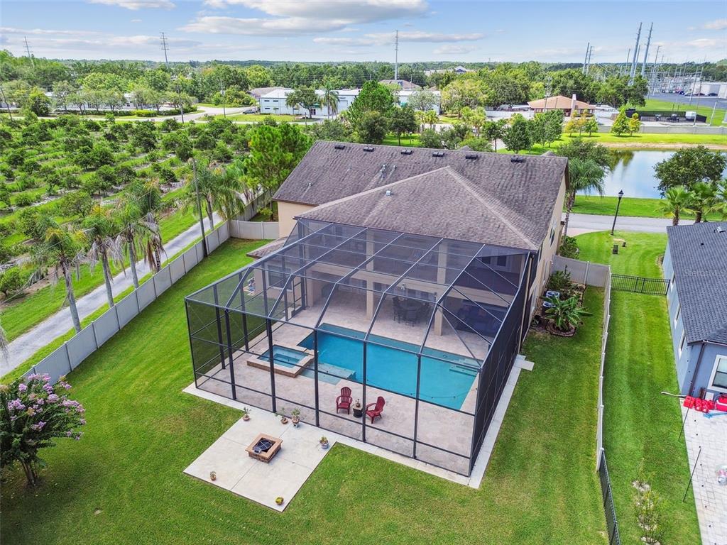 An aerial view of a two-story house with a screened-in pool, spa, and backyard patio — 2566 LAKE MANOR DRIVE, LAND O LAKES, FL